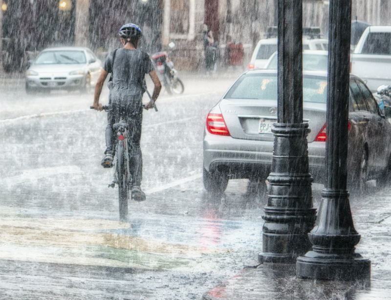 man riding a bicycle in rain